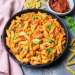 Creamy Tuscan chicken pasta ingredients with chicken, penne, sun-dried tomatoes, spinach and Parmesan